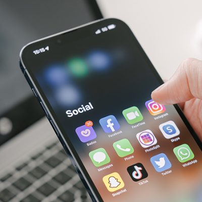 Phone open to folder titled "Social" with Instagram, Facebook and Twitter apps visible